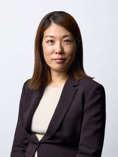 ダークスーツを着て正面を見つめる廣田ふみ氏のポートレート写真